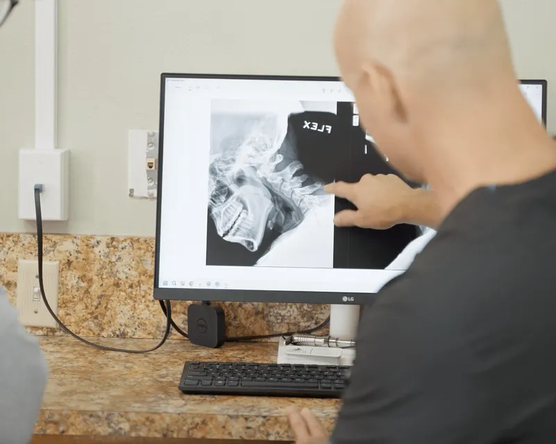 Dr. Woodbury reviewing a neck X-ray on screen with a patient